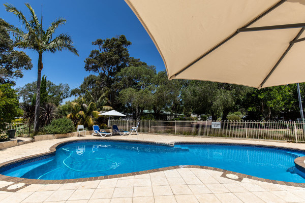 View over the pool at Margaret River Caravan Park, a family friendly RV park in WA.